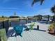 Waterfront dock with chairs overlooking canal with boat lifts and neighboring houses on a sunny day at 14970 Appleton Blvd, Port Charlotte, FL 33981
