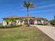 Well-maintained single-story home with a lush lawn and mature palm trees at 14970 Appleton Blvd, Port Charlotte, FL 33981