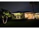 Exterior night shot featuring a home with manicured landscaping and decorative outdoor lighting at 14970 Appleton Blvd, Port Charlotte, FL 33981