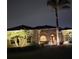 Exterior night shot featuring a home with manicured landscaping and decorative outdoor lighting at 14970 Appleton Blvd, Port Charlotte, FL 33981