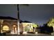 Inviting home exterior at twilight featuring arched windows, palm trees, and a circular driveway at 14970 Appleton Blvd, Port Charlotte, FL 33981