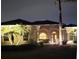 Beautifully lit home exterior boasts lush landscaping and a welcoming entrance at 14970 Appleton Blvd, Port Charlotte, FL 33981