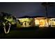 Night shot of home exterior with manicured lawn, palm trees, and welcoming front door at 14970 Appleton Blvd, Port Charlotte, FL 33981