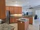 Open-concept kitchen features granite countertops, a center island, and stainless steel appliances at 14970 Appleton Blvd, Port Charlotte, FL 33981