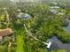 A beautiful aerial view highlighting the property's access to the canal, including a dock and lush landscaping at 150 N Oxford Dr, Englewood, FL 34223