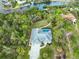 Aerial view of home with a private pool, surrounded by lush landscaping and a curving driveway at 150 N Oxford Dr, Englewood, FL 34223