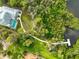 Aerial shot of a home with a pool and pathway to the waterfront with dock at 150 N Oxford Dr, Englewood, FL 34223