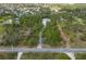 Bird's eye view of a home on a large, wooded lot with mature trees and a long driveway at 150 N Oxford Dr, Englewood, FL 34223