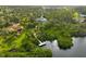 Scenic aerial view of a waterfront property featuring a dock and dense foliage, offering privacy and natural beauty at 150 N Oxford Dr, Englewood, FL 34223