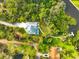 Aerial view of a home with a private pool, mature trees, and access to waterfront at 150 N Oxford Dr, Englewood, FL 34223
