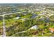 Expansive aerial view of a waterfront property with lush greenery and a winding canal at 150 N Oxford Dr, Englewood, FL 34223