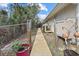 Backyard concrete path leading to the entrance of the house with fencing and landscaping at 150 N Oxford Dr, Englewood, FL 34223