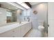 Bright bathroom with white tile floors, a large vanity, and modern fixtures at 150 N Oxford Dr, Englewood, FL 34223