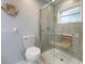 Bathroom featuring a toilet and a glass-enclosed shower with a built-in seat at 150 N Oxford Dr, Englewood, FL 34223