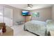 Comfortable bedroom features a ceiling fan, wall-mounted TV, and a bright window at 150 N Oxford Dr, Englewood, FL 34223