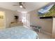 Relaxing bedroom boasts a wall-mounted television, ceiling fan and tile flooring at 150 N Oxford Dr, Englewood, FL 34223