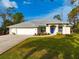 Charming single-story home with manicured front lawn and welcoming blue front door at 150 N Oxford Dr, Englewood, FL 34223