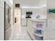 Bright kitchen featuring white cabinets, stainless steel appliances, and a unique rounded island with shelving at 150 N Oxford Dr, Englewood, FL 34223