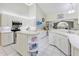 Spacious kitchen with white cabinets, stainless appliances, an island with shelving and views to the backyard at 150 N Oxford Dr, Englewood, FL 34223