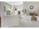 White kitchen featuring sleek appliances, breakfast bar, and tile flooring at 150 N Oxford Dr, Englewood, FL 34223