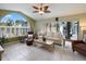 Well-lit living room with a large arched window offering a view of the backyard pool area at 150 N Oxford Dr, Englewood, FL 34223