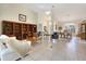 Open-concept living room with large bookcase and dining area, all with tile flooring at 150 N Oxford Dr, Englewood, FL 34223