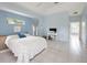 Bright main bedroom with tiled floors, a tray ceiling, and a dedicated workspace at 150 N Oxford Dr, Englewood, FL 34223