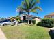 Charming single-story home showcases a lush green lawn and mature palm trees creating a tropical feel at 15408 Feather Star Pl, Ruskin, FL 33573