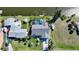 Aerial view of a home featuring screened-in pool, boat dock and lift, and lush landscaping at 15652 Ruston Cir, Port Charlotte, FL 33981