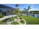 Lush backyard featuring waterfront views, tropical foliage, and a charming garden near the screened-in pool area at 15652 Ruston Cir, Port Charlotte, FL 33981