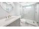 This bright bathroom includes an oval sink, and a glass shower stall with white stone floor at 15652 Ruston Cir, Port Charlotte, FL 33981