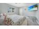 A bright bedroom with light gray wood floors, a flatscreen tv, a large window, and a closet at 15652 Ruston Cir, Port Charlotte, FL 33981