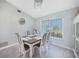 Dining room features grey wood-look flooring, decorative chandelier, and a view of the front yard at 15652 Ruston Cir, Port Charlotte, FL 33981
