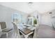Dining room with wainscotting, chandelier, grey wood-look flooring, and a view of the front yard at 15652 Ruston Cir, Port Charlotte, FL 33981