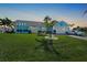 Charming blue home with well-manicured lawn, palm trees, and a classic white Corvette in the driveway at 15652 Ruston Cir, Port Charlotte, FL 33981
