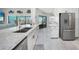 Modern kitchen features white cabinets, stainless steel appliances, granite countertops, and wood-look floors at 15652 Ruston Cir, Port Charlotte, FL 33981
