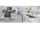 Kitchen with stainless steel appliances, white cabinetry, granite countertop, and wood-look flooring at 15652 Ruston Cir, Port Charlotte, FL 33981