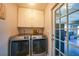 Practical laundry area equipped with modern appliances and storage, leading to an outdoor area at 15652 Ruston Cir, Port Charlotte, FL 33981