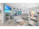Bright living room with white leather sofas, mounted TV, and sliding glass doors to the pool at 15652 Ruston Cir, Port Charlotte, FL 33981