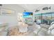 Open-concept living room featuring a pool view, vaulted ceiling, coastal decor, and light grey interior paint at 15652 Ruston Cir, Port Charlotte, FL 33981
