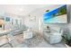 Comfortable living room with vaulted ceiling, light grey decor, modern ceiling fan and coastal themed wall decor at 15652 Ruston Cir, Port Charlotte, FL 33981