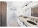 A bright bathroom with wood floors, a marble double sink vanity, and a glass shower stall at 15652 Ruston Cir, Port Charlotte, FL 33981