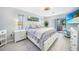 Bright main bedroom with king bed, gray wood floors, ceiling fan, and access to patio with hot tub at 15652 Ruston Cir, Port Charlotte, FL 33981