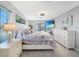 This main bedroom features light gray wood floors, a ceiling fan, a flatscreen tv, and outdoor access at 15652 Ruston Cir, Port Charlotte, FL 33981