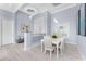 Cozy dining room with white table and chairs, stylish lighting, and light-colored hardwood flooring at 16 Yellowhammer Dr, Placida, FL 33946