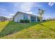 Well-maintained backyard with lush green grass, landscaping, and a screened lanai at 16273 Coconut Palm Dr, Port Charlotte, FL 33953