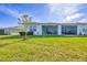 Expansive backyard features green lawn, tasteful landscaping, and an inviting screened lanai at 16273 Coconut Palm Dr, Port Charlotte, FL 33953