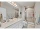 Bright bathroom featuring a large double vanity, walk-in shower with glass doors, and modern fixtures and finishes at 16273 Coconut Palm Dr, Port Charlotte, FL 33953