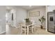 Cozy dining area features a modern table, chairs, stainless steel refrigerator, and natural lighting at 16273 Coconut Palm Dr, Port Charlotte, FL 33953