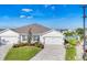 Attractive exterior elevation showcasing a well-maintained yard, double garage, and paver driveway at 16273 Coconut Palm Dr, Port Charlotte, FL 33953